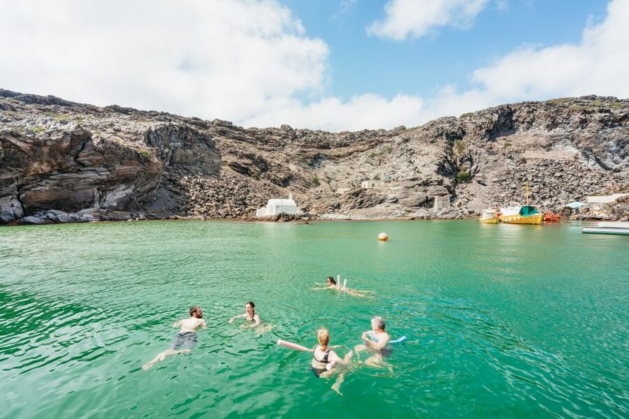 Santorini: Luxury Catamaran Day Trip with Meal and Open Bar - Sailing below Fira and toward Oia